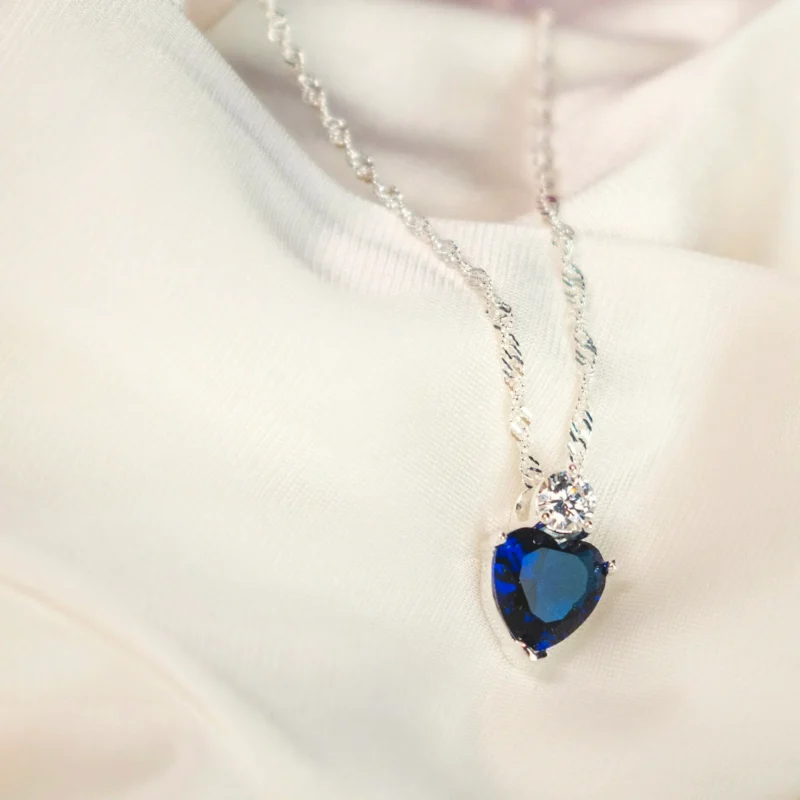 Collana Cuore Blu — Cuore in cristallo blu su catena chiara.